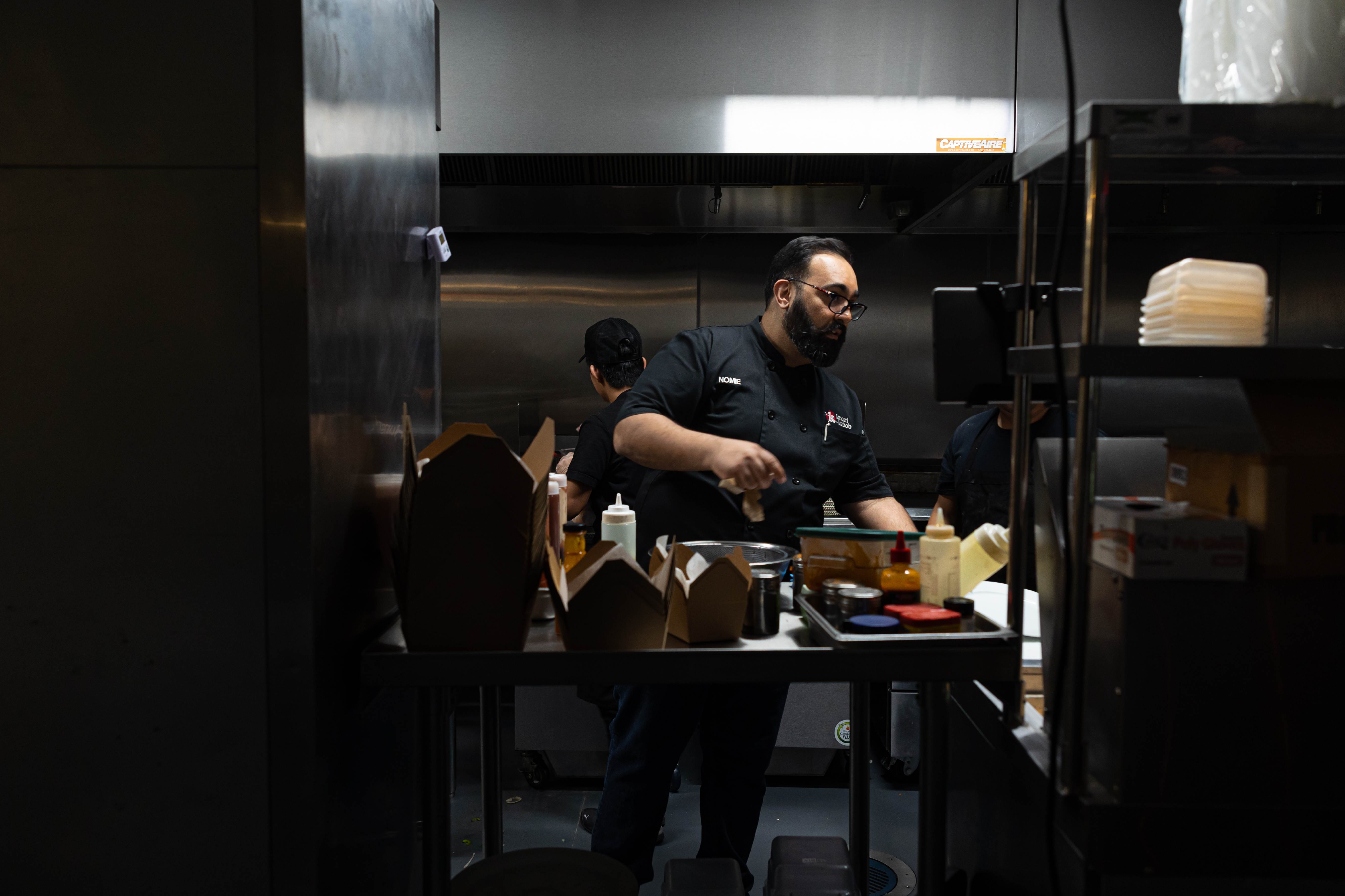Chef Nomie preparing orders in the VXK kitchen